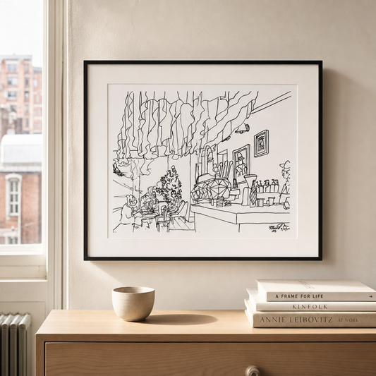 Caffe Aronne art print framed in a black gallery frame hanging on a wall above a wooden console